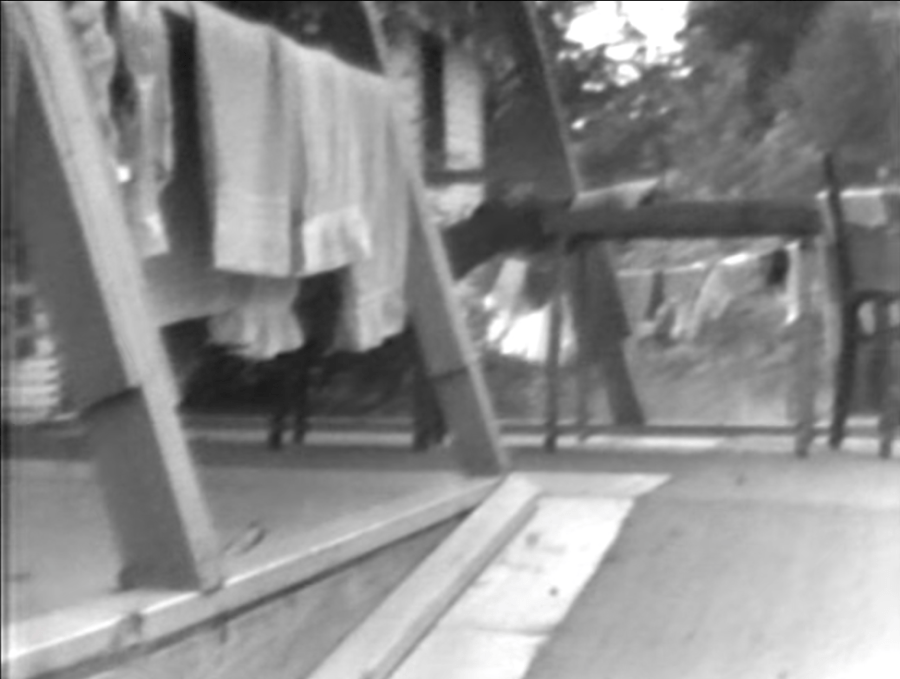 A shot from archival footage in which LeBrecht and the camera move up a ramp to the girls’ dorm.