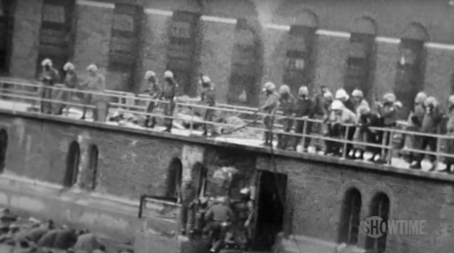 Black and white image of police holding guns on inmates during Attica prison riot