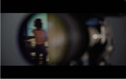 A blurry image of a naked body refracted through a camera lens