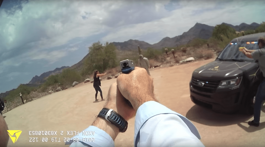three guns pointed at a stuffed dummy in the desert