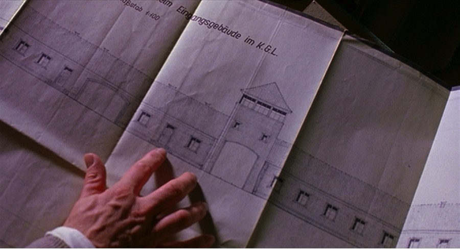 a hand hovers over architectural blueprints