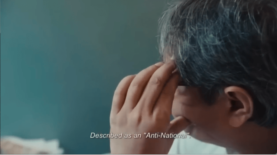 A man begins to run his fingers through his hair in frustration