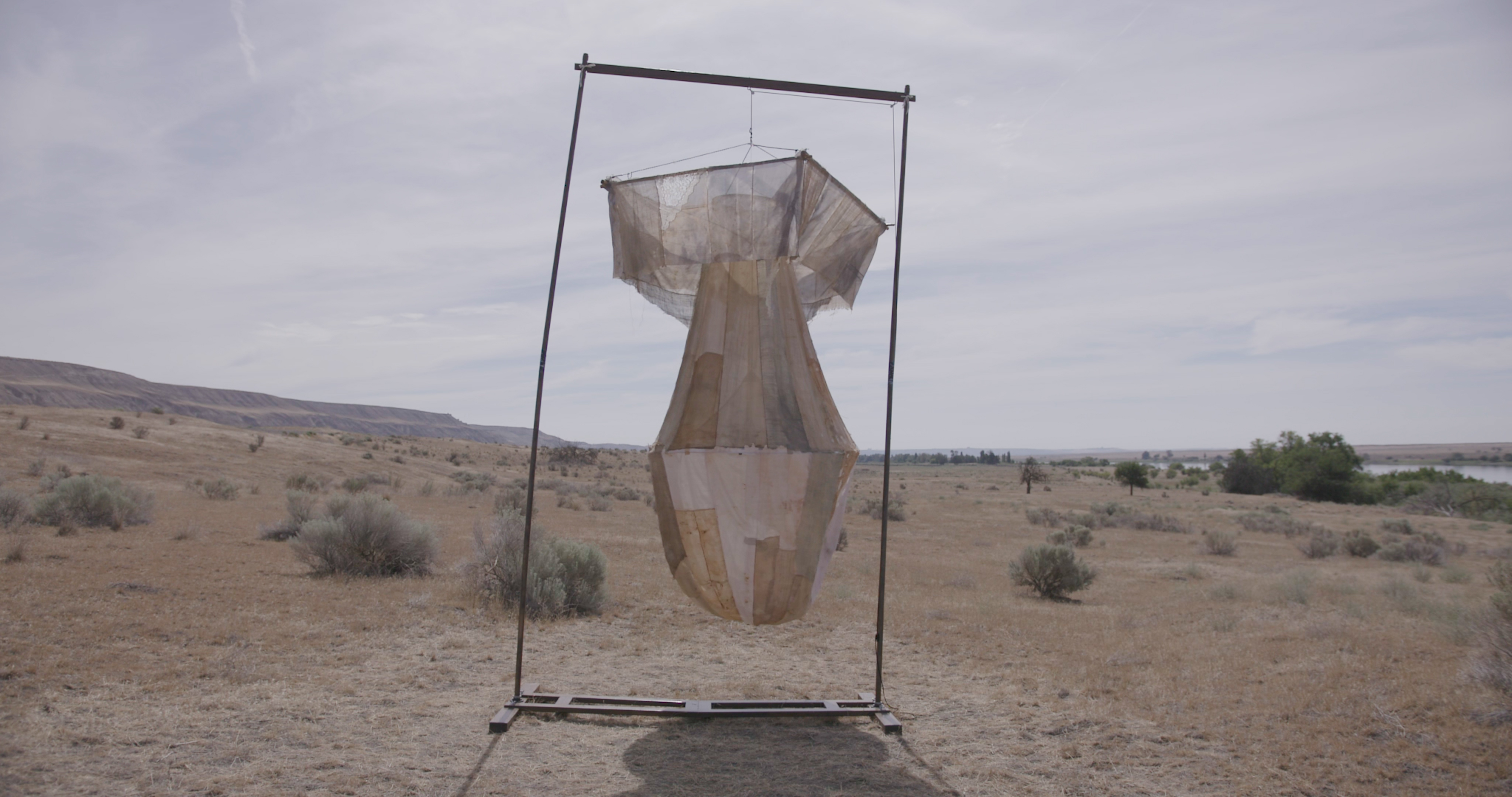 A wind sock shaped like a bomb displayed in a barren landscape